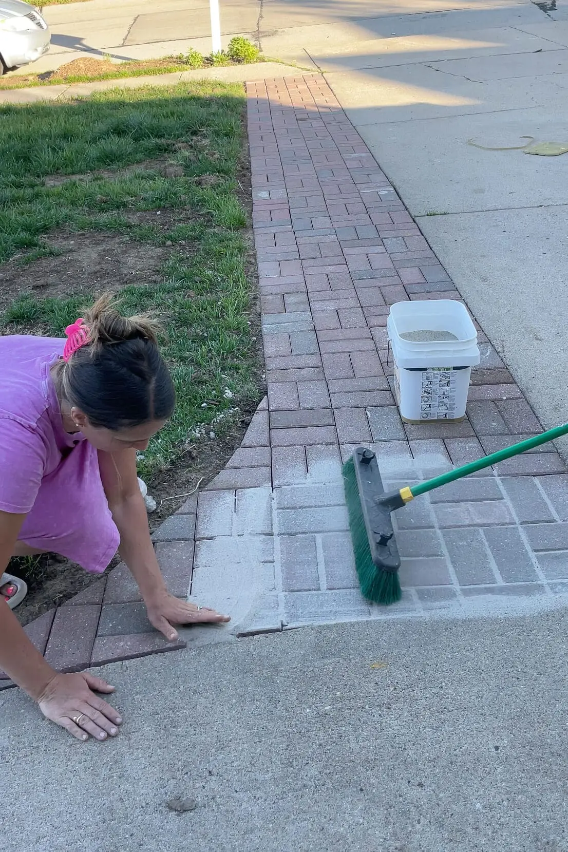 Using polymer sand to finish a paver driveway extension.